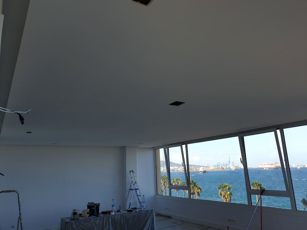 Oficina con falso techo de pladur en obra y vistas al mar