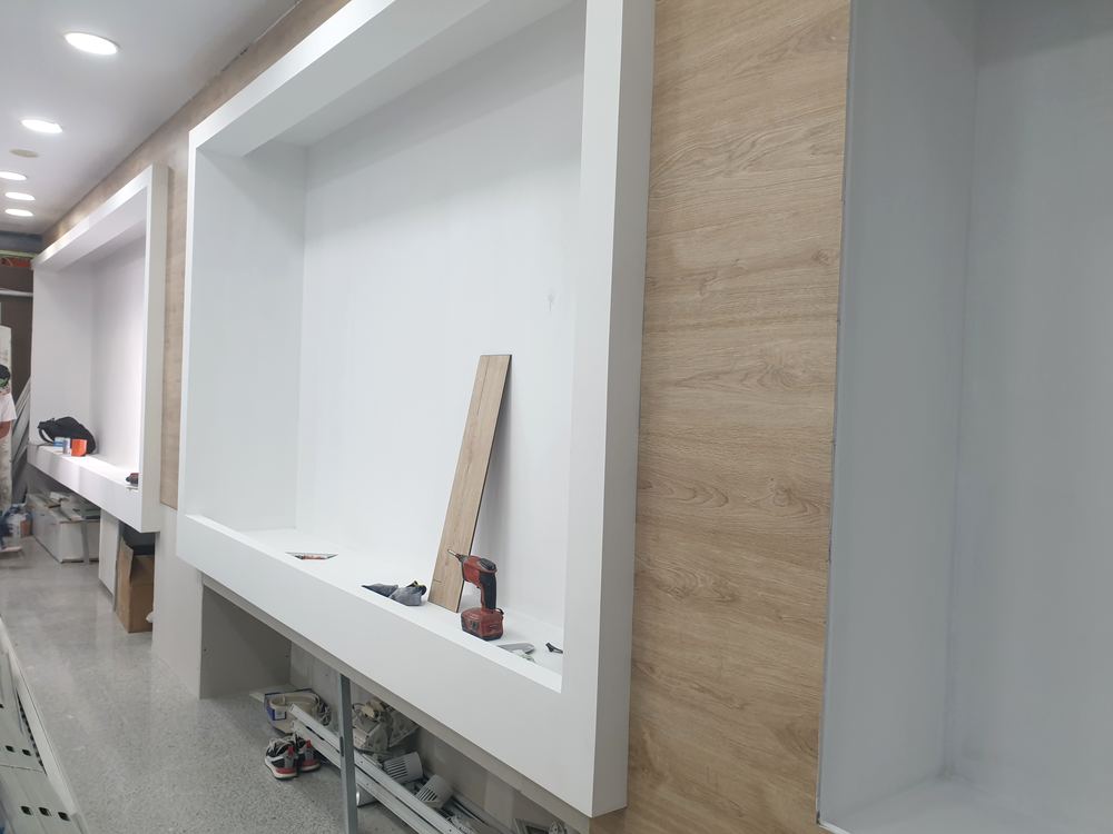 Local comercial con hornacinas de pladur y paneles de madera